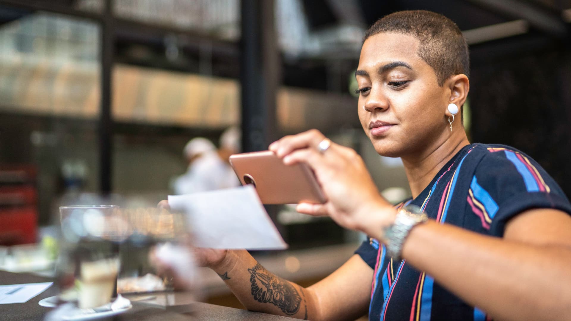 Junge Frau macht ein Foto von einem Papier.