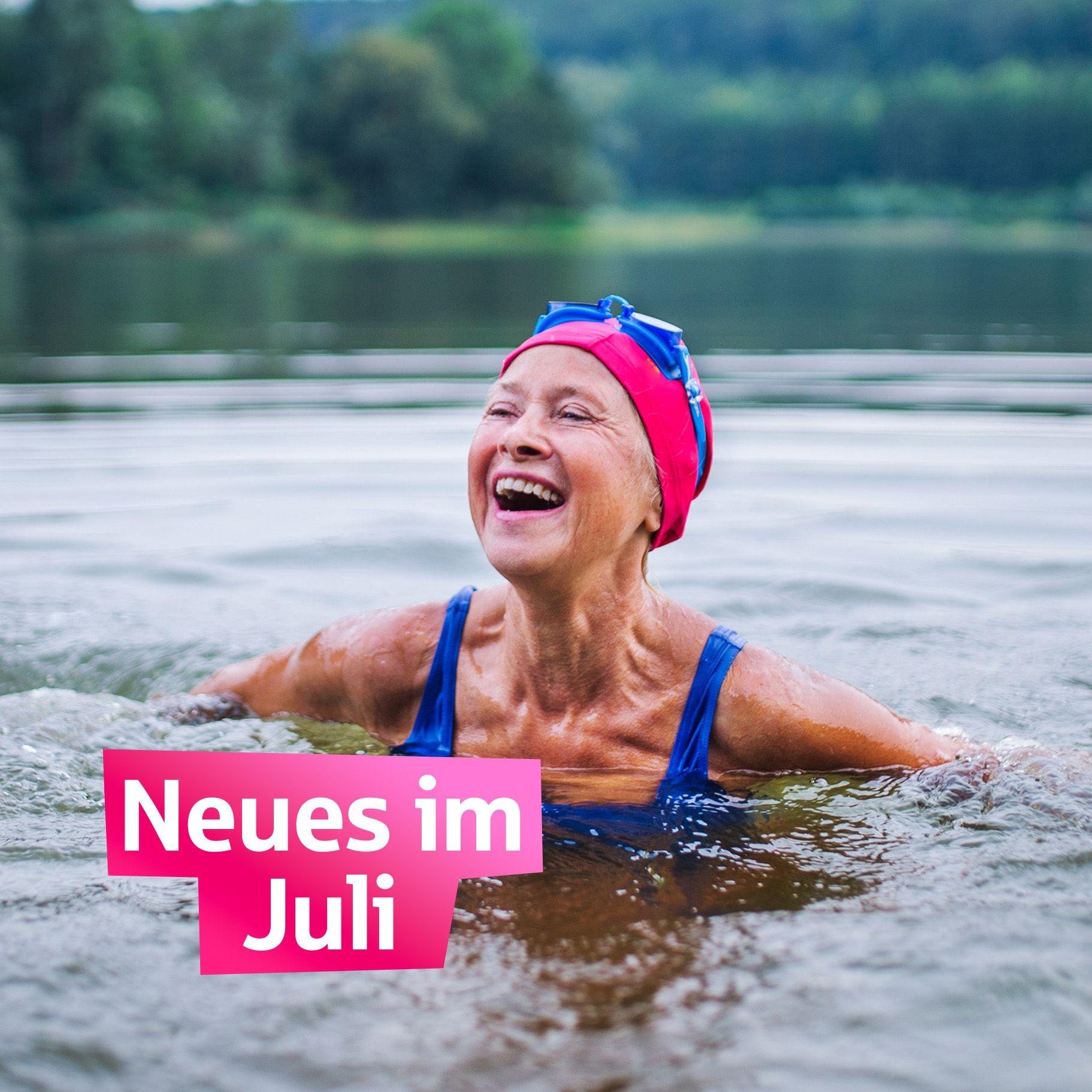 Neues im Juli eine lachende Seniorin mit Badekappe schwimmt in einem See
