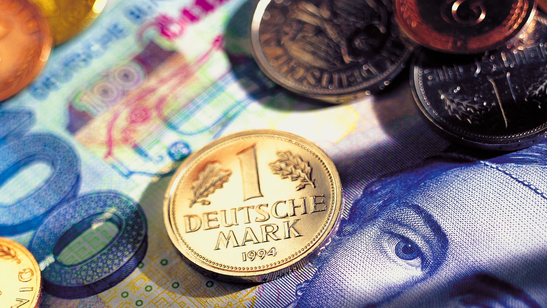 DM-Münzen liegen auf einen 100-Mark-Geldschein.