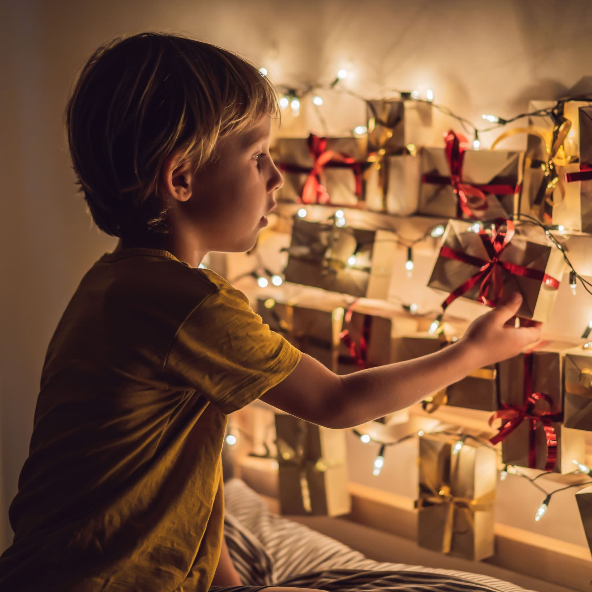The boy opens a gift from the advent calendar