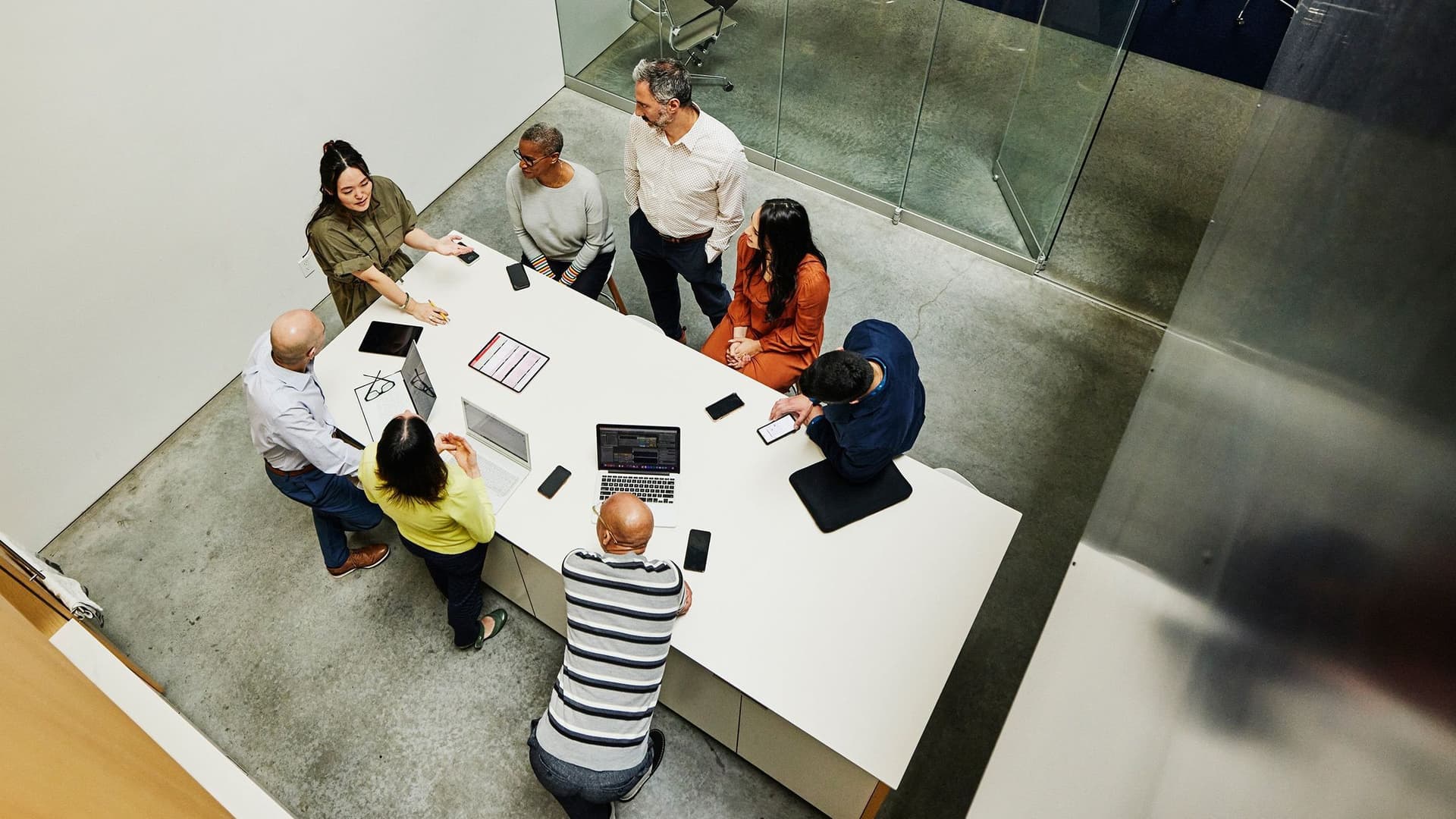 Eine Gruppe im Büro beim Brainstormen. Das Bild wurde in der Vogelperspektive aufgenommen.