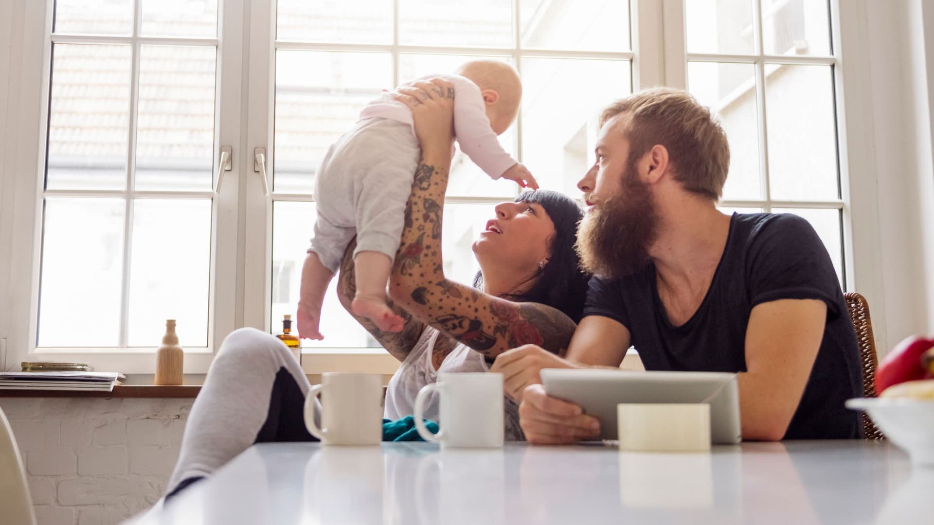 Junge Familie mit Säugling am Küchentisch