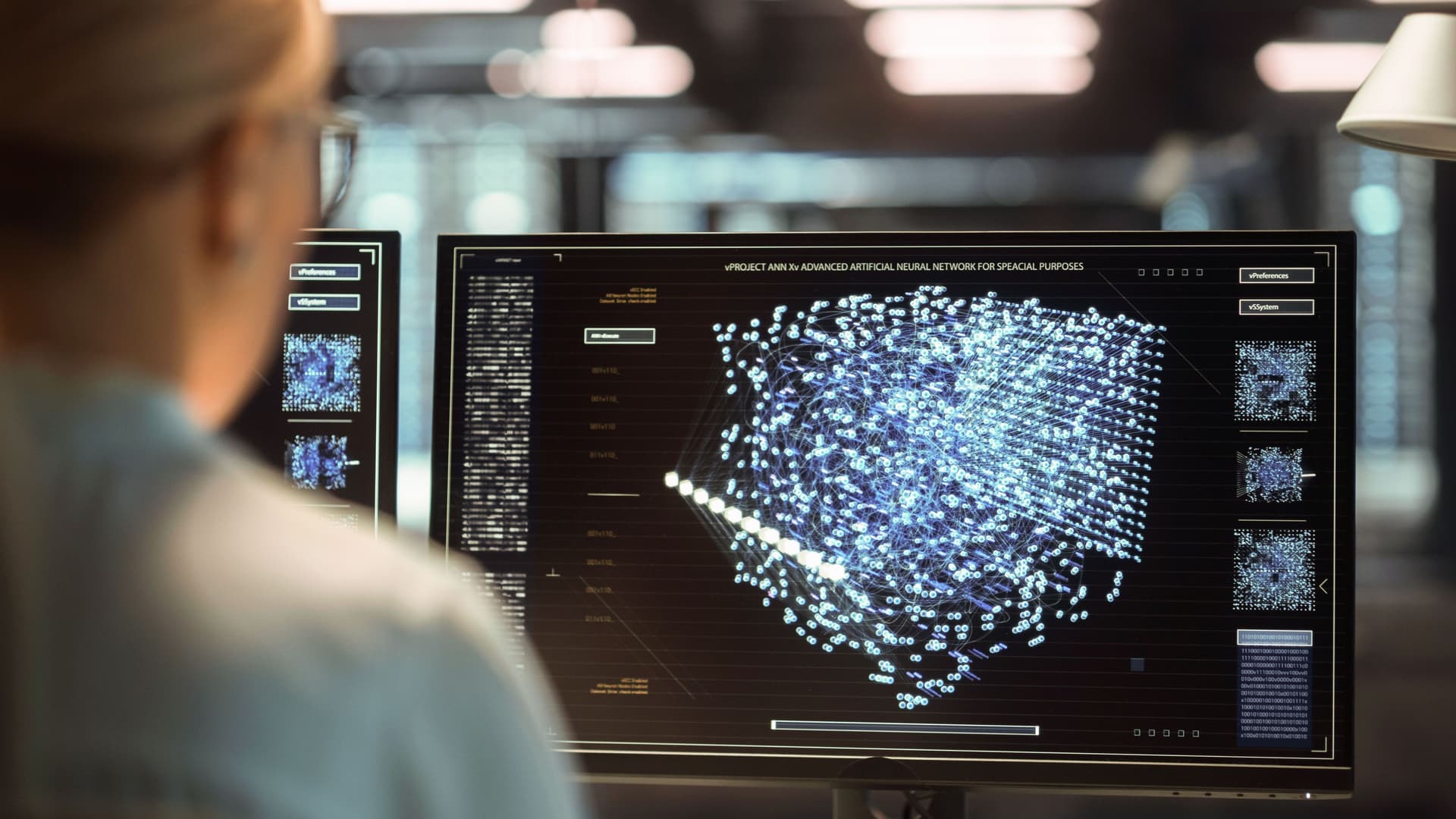 Blockchain für Unternehmen Person arbeitet am Arbeitsplatz mit mehreren Displays in einem Systemkontrollraum.