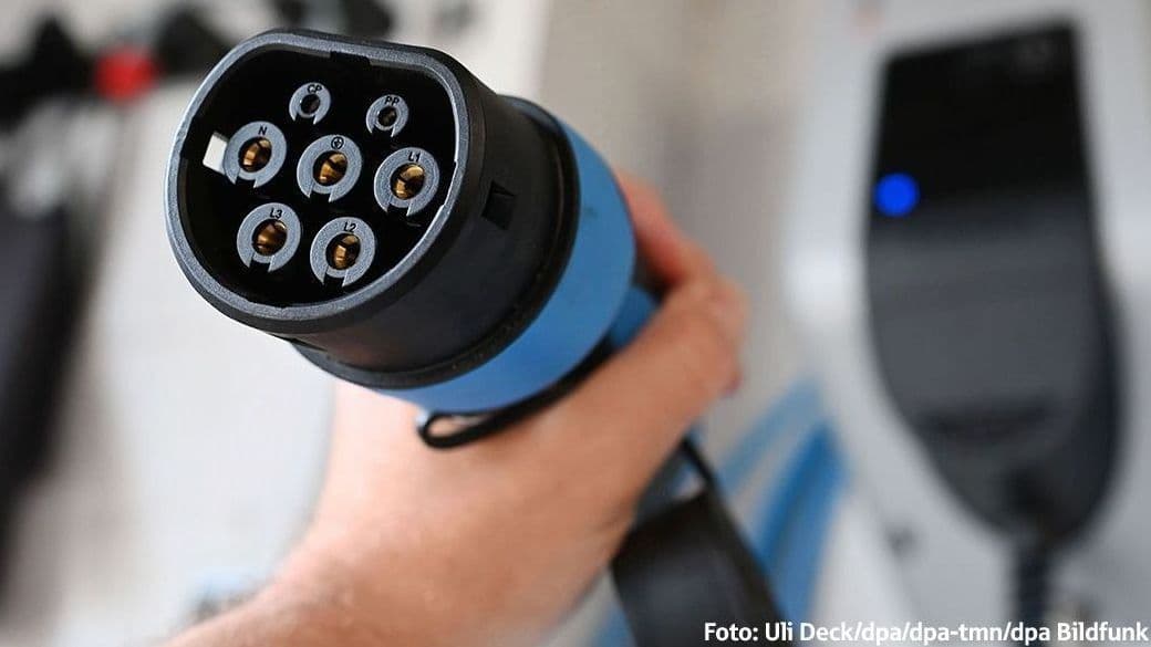 Hand hällt Ladestecker einer Wallbox