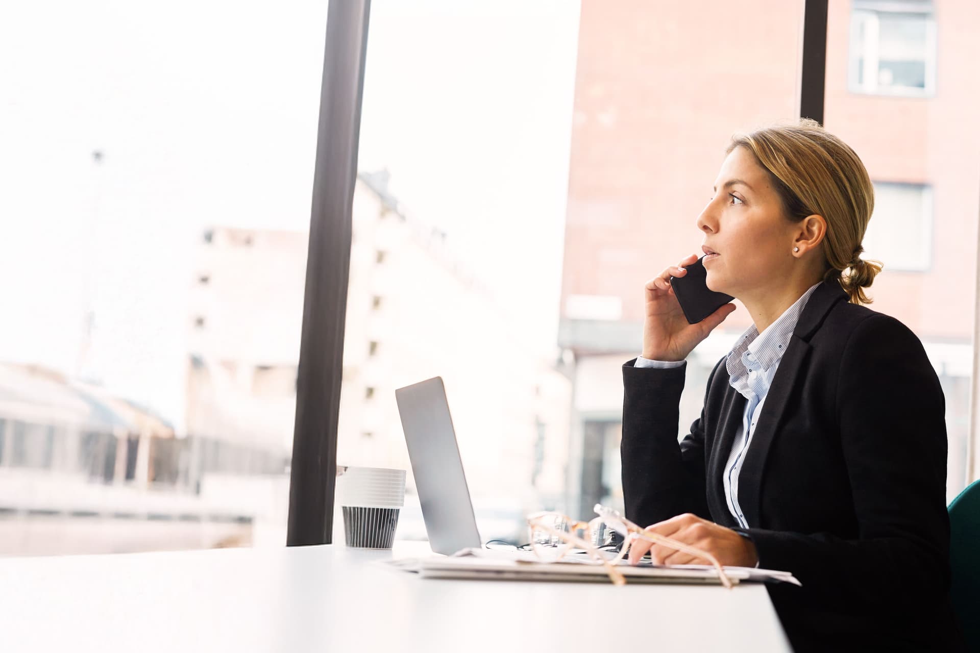 Selbstbewusste Geschäftsfrau im Gespräch am Smartphone im Büro