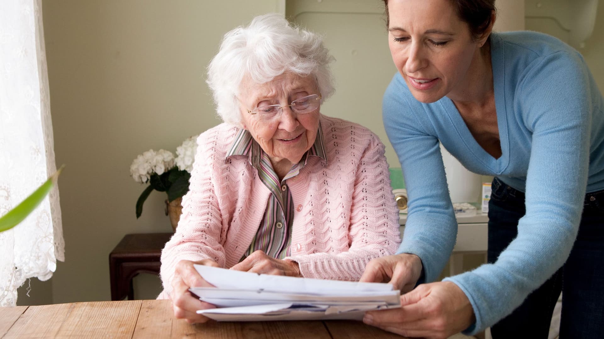 Eine Pflegerin geht mit einer Seniorin Unterlegen durch.
